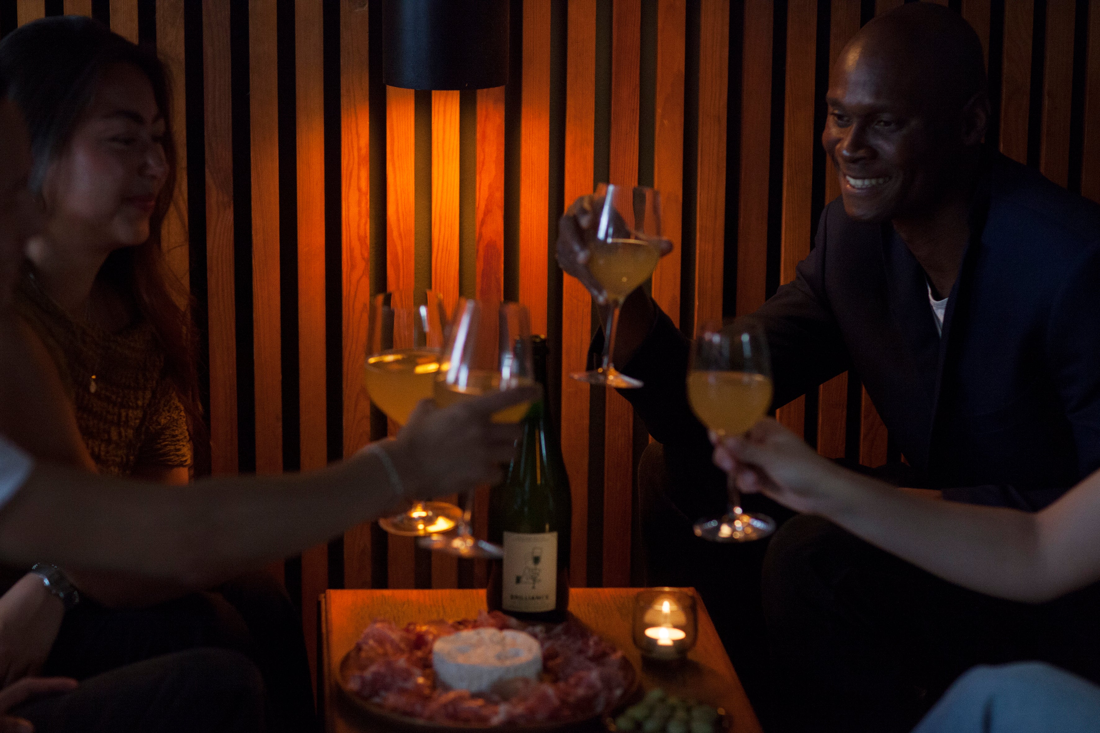 Friends enjoying sparkling cava-infused craft kombucha in a local Copenhagen bar paired with cured meats and cheese.